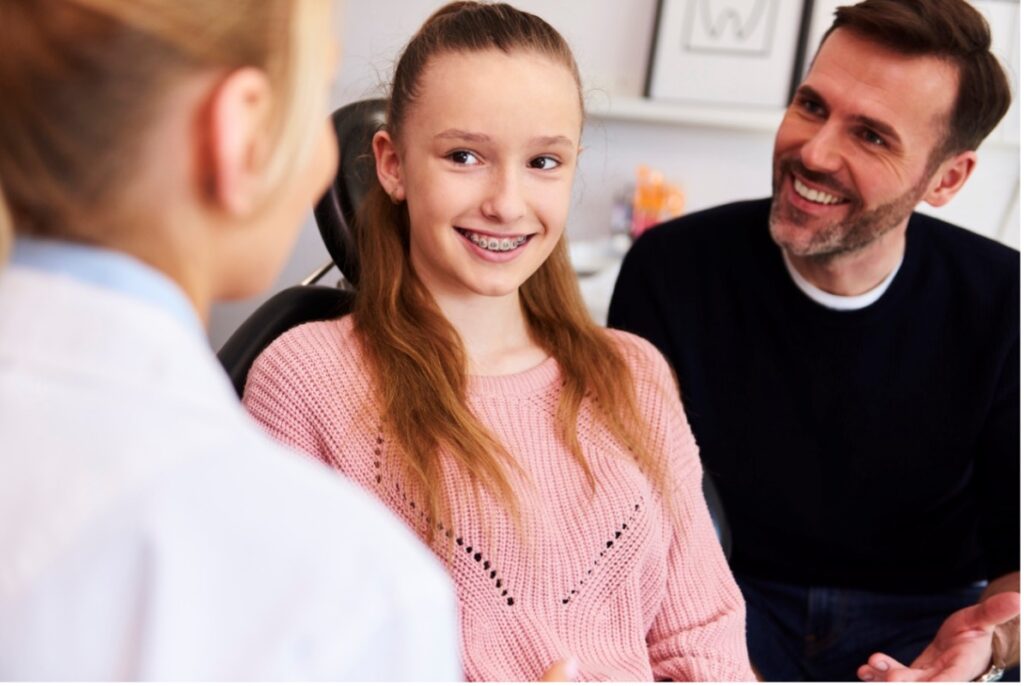 A young person and their father smiling, When Should My Child See an Orthodontist?