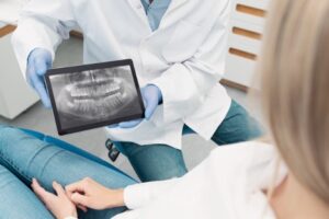 A doctor showing a x-ray of a patient, The Importance of Visiting an Orthodontist in Person