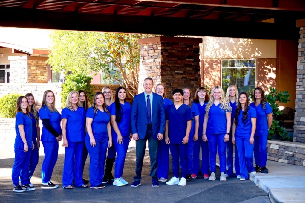 A group of people in blue uniforms, At Ortho Specialists, Your Treatment is Backed by a Team of Professionals