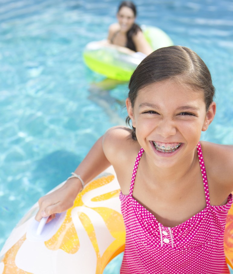 A child with braces smiling at camera, Summer Fun with Braces: Advice from Orthodontic Specialists in St. George