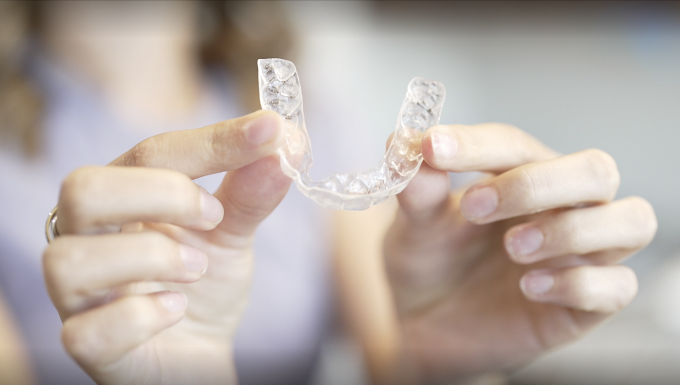 a person holding clear aligners