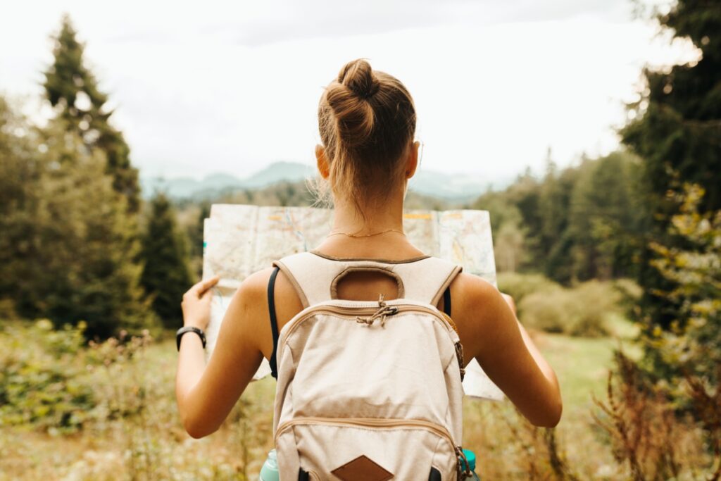 A person with a backpack looking at a map