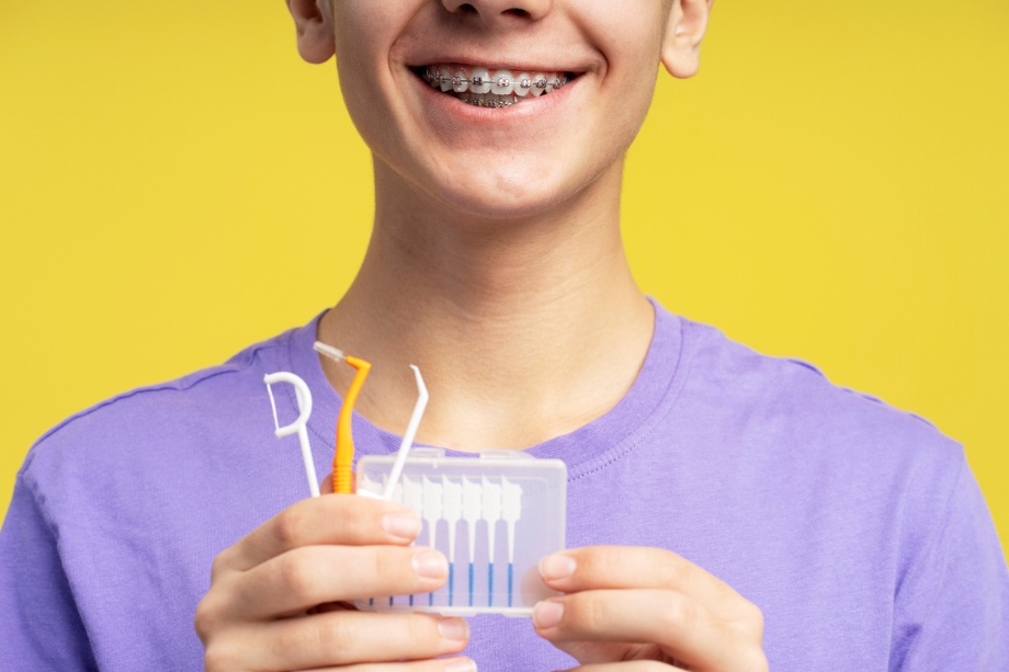 playing sports safely with braces, A teenager holding flossing equipment