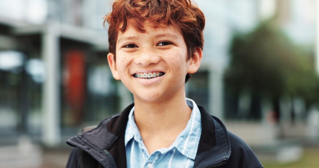 School-friendly orthodontic options., A boy with braces smiling