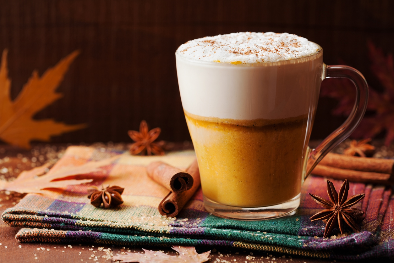 Starting Orthodontic Treatment, Pumpkin spiced latte or coffee in a glass on a rustic table. Autumn or winter hot drink.