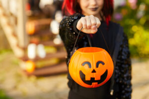 Braces-Friendly Halloween Treats: How to Keep Your Smile Safe This Spooky Season, a kid holding up a pumpkin bucket